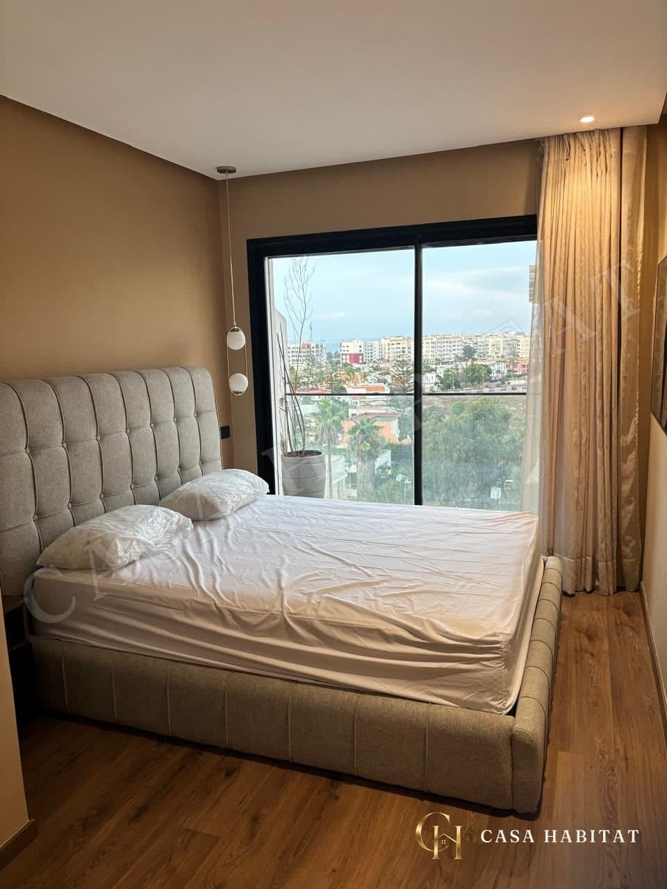 Chambre avec lit capitonné et vue sur les toits