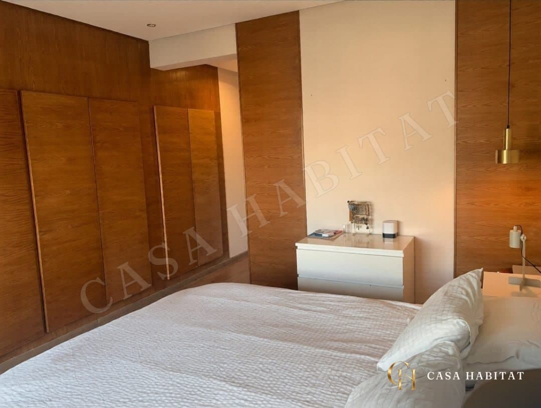 Chambre avec placards en bois et lit blanc