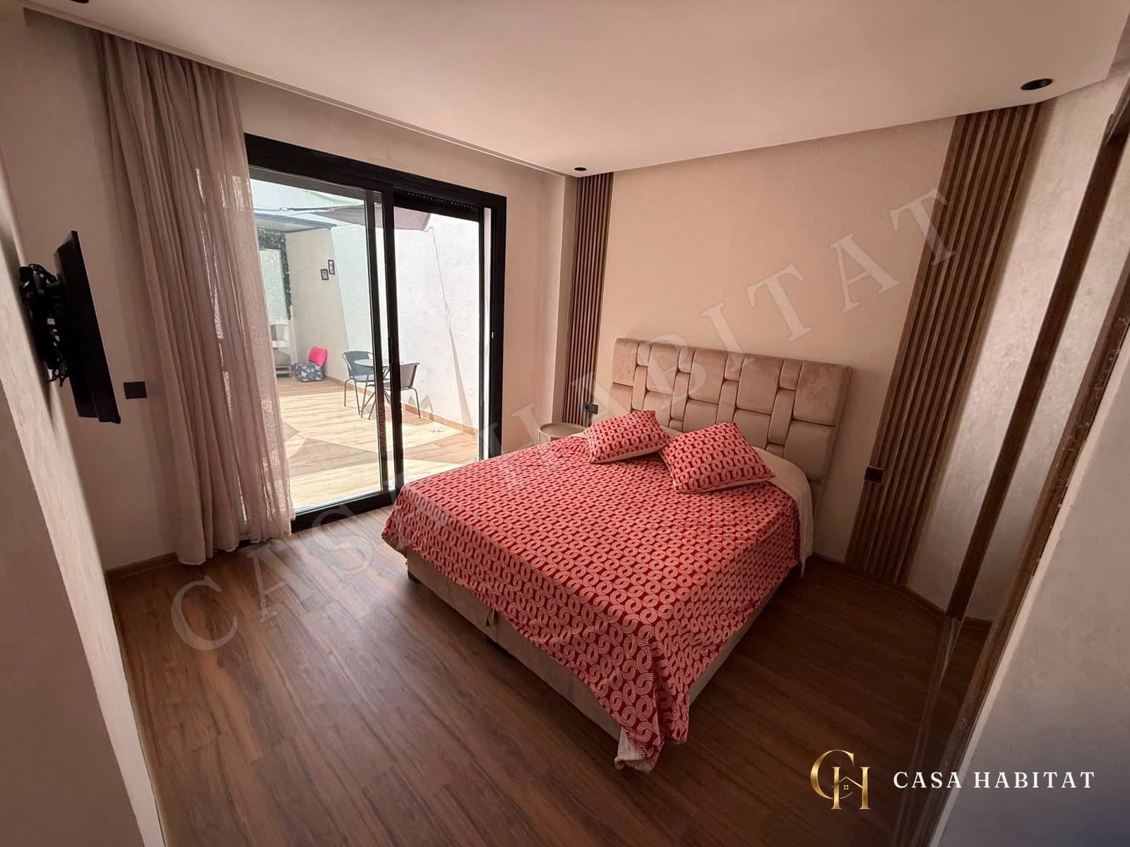 Chambre avec lit à tête capitonnée rouge et accès à la terrasse