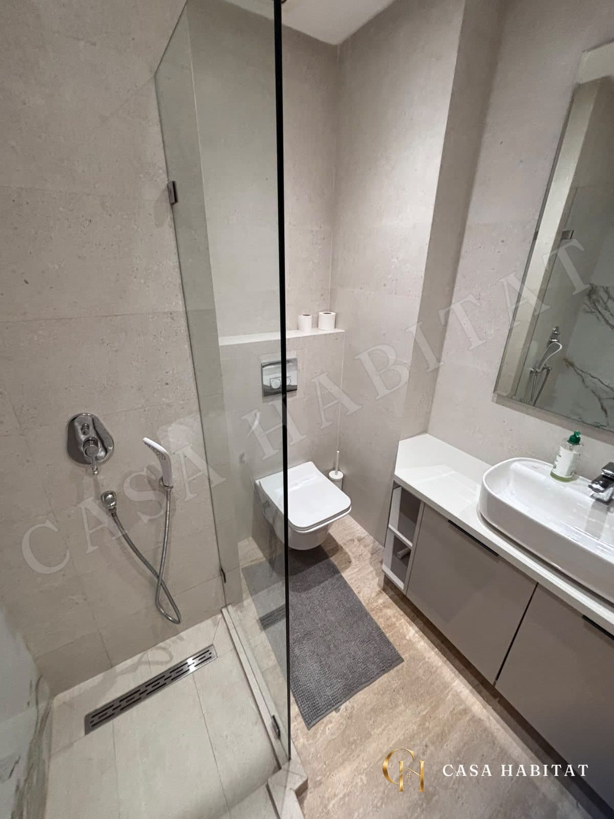 Salle de bain avec douche à l'italienne, WC suspendu et lavabo
