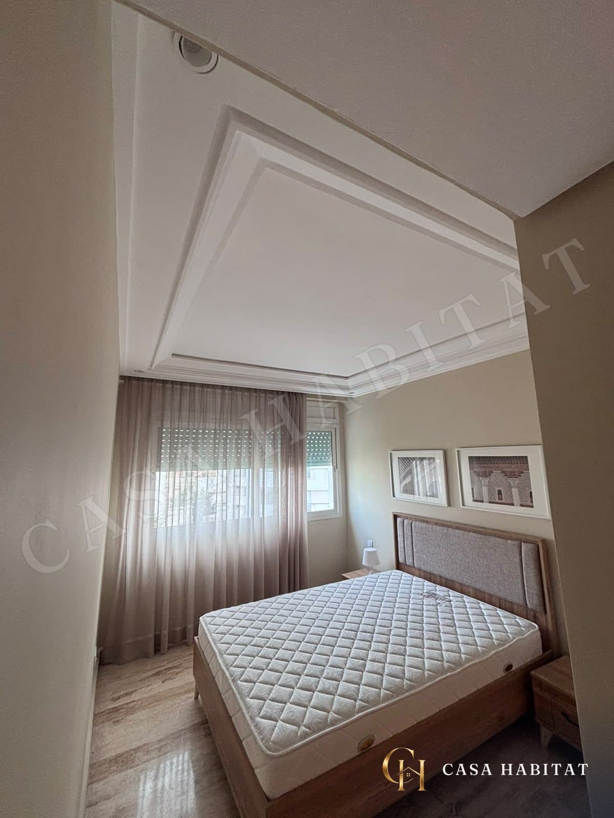 Chambre avec matelas sur sommier et rideaux voilage