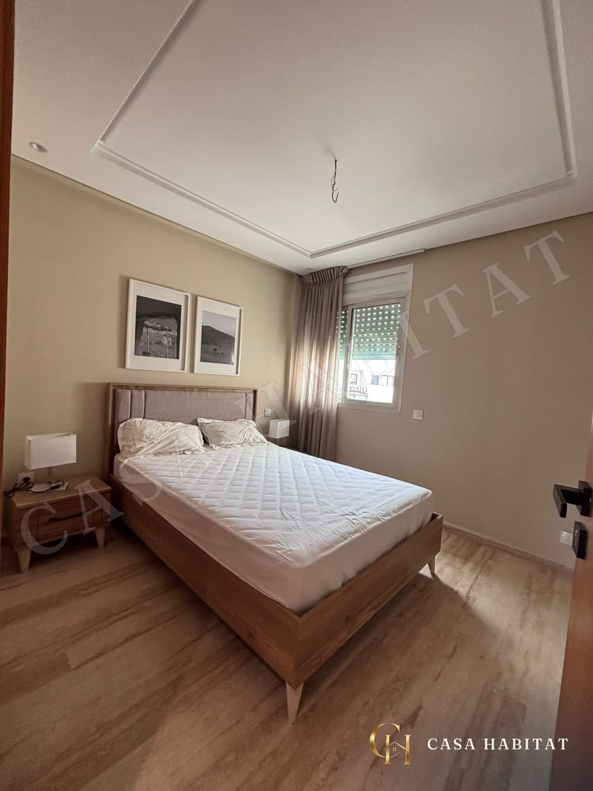 Chambre avec lit double, table de chevet et fenêtre