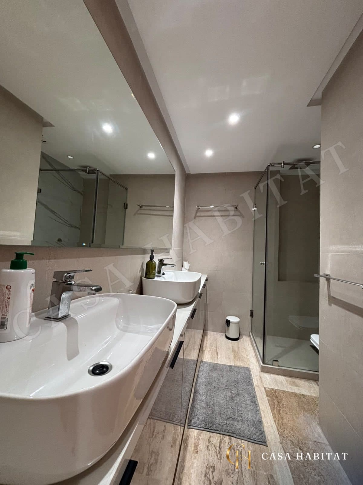 Salle d'eau avec double vasque, miroir et cabine de douche