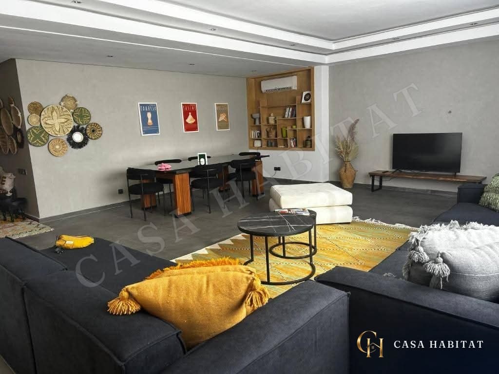 Salon avec canapés anthracite, coussins jaunes et table basse