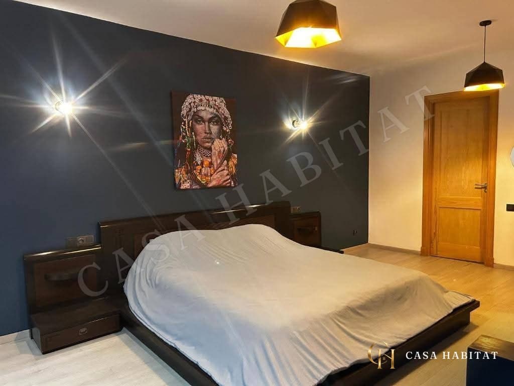 Chambre avec lit double, tableau et lampes murales