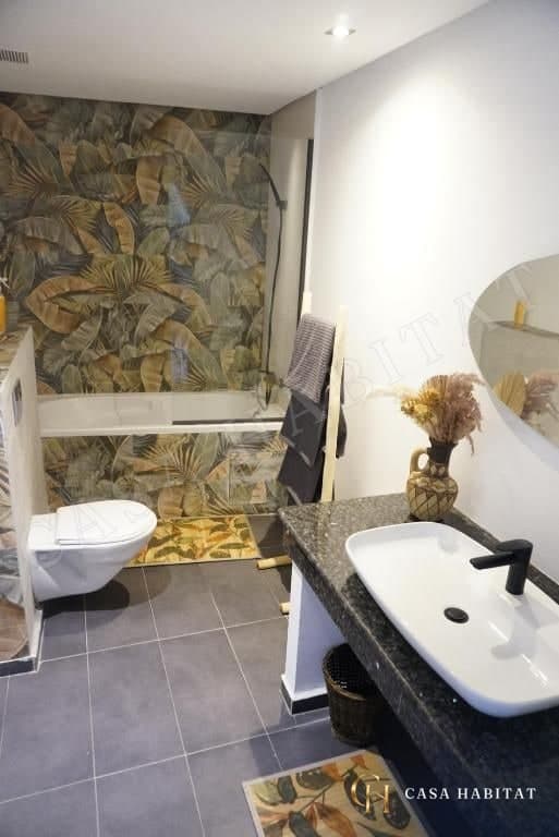 Salle de bain avec baignoire, WC et meuble vasque