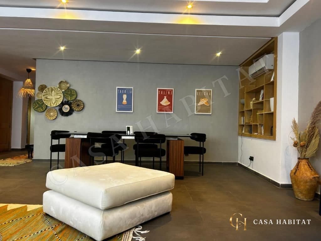 Salle à manger avec table, chaises noires et affiches murales