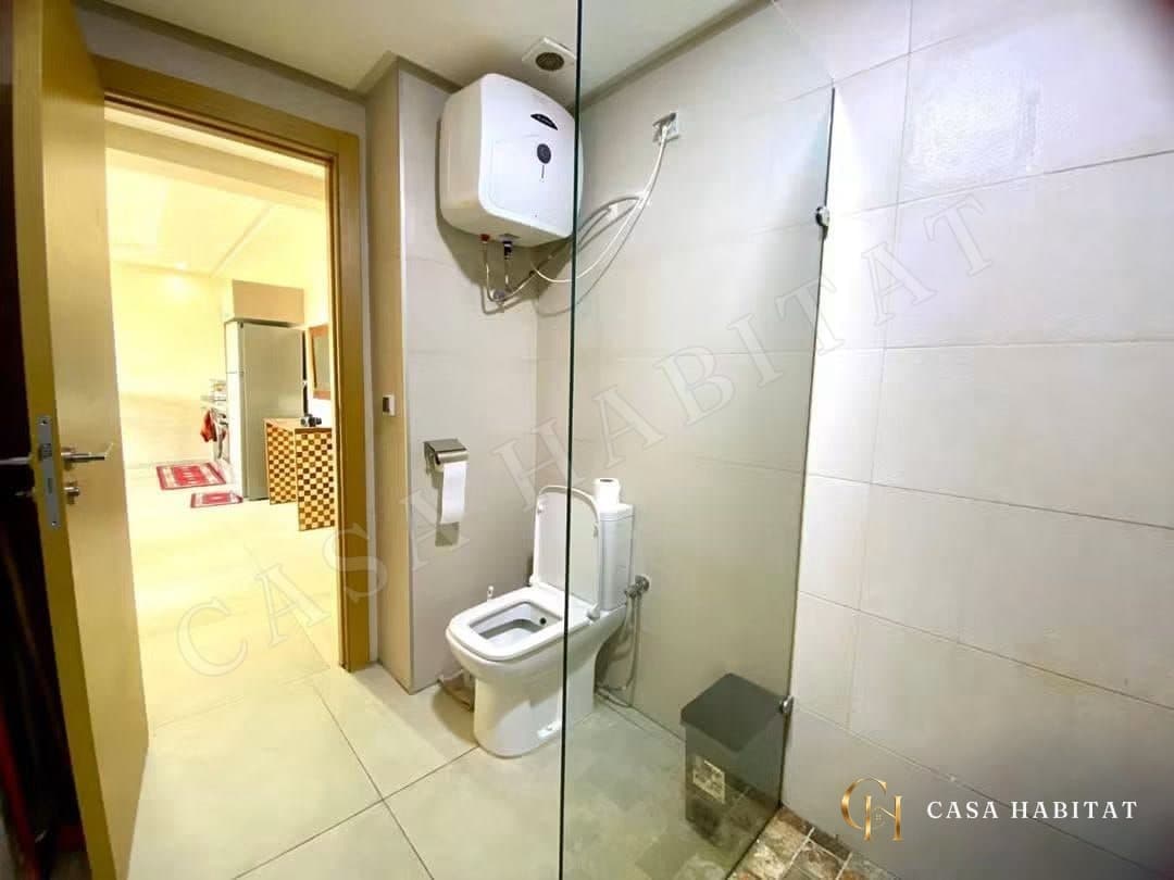 Salle d'eau avec douche en verre, WC et chauffe-eau