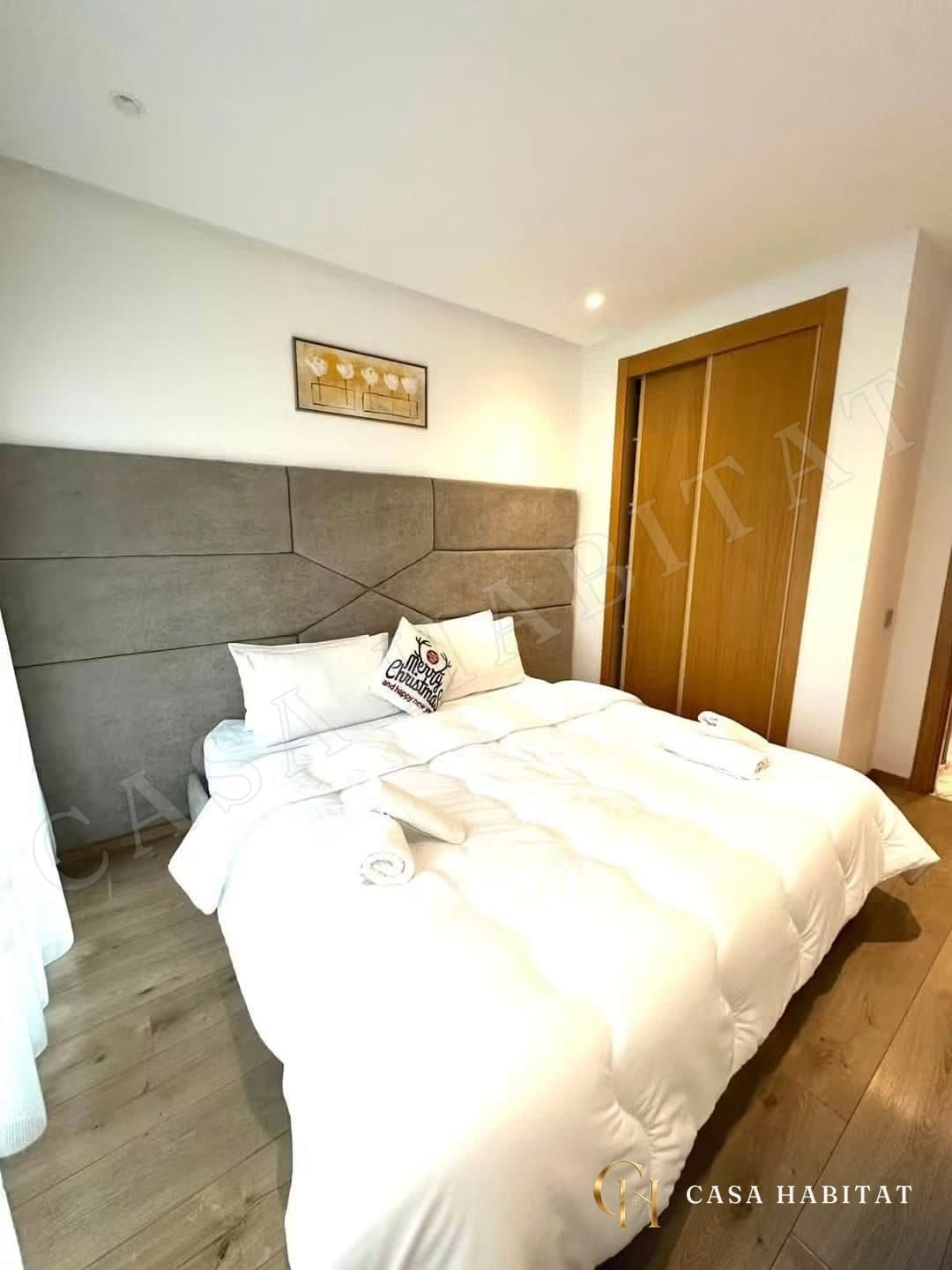 Chambre avec lit blanc et tête de lit grise