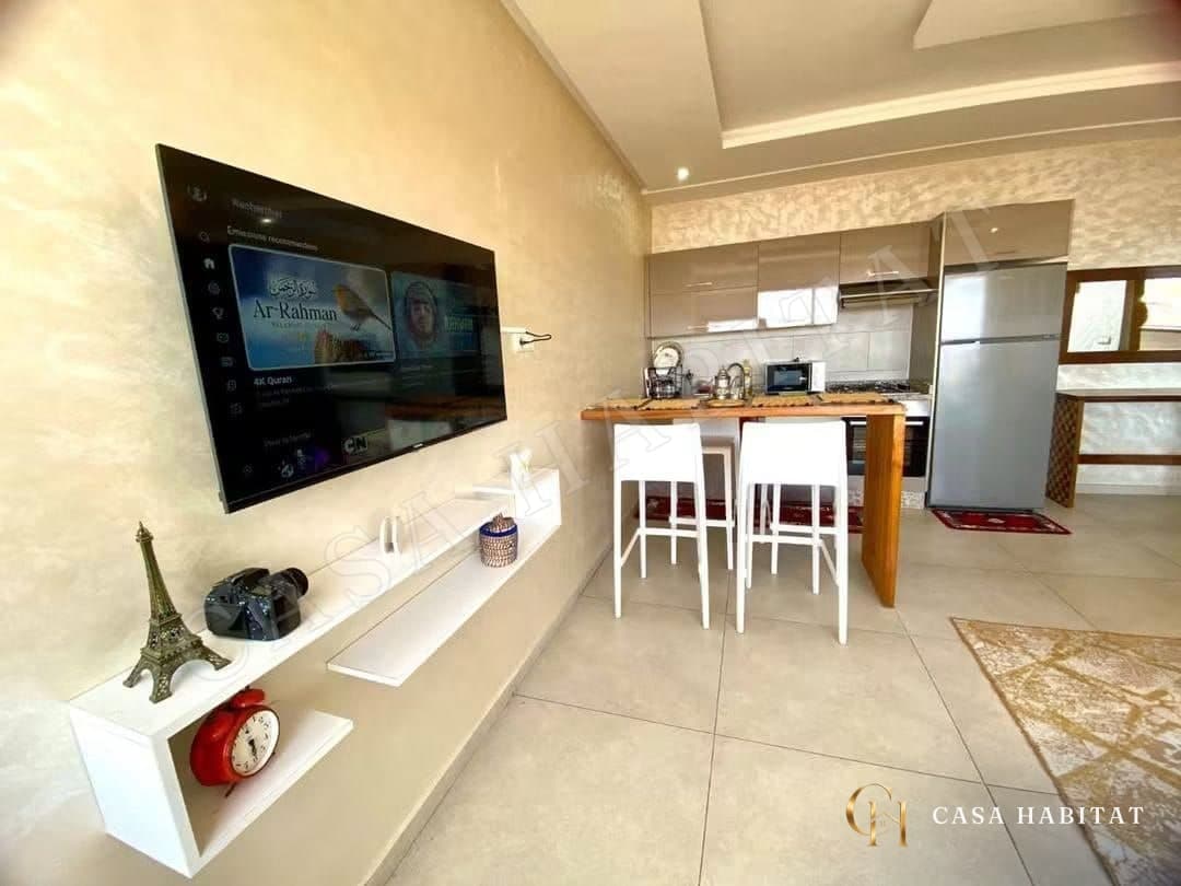 Coin TV et cuisine ouverte avec bar et tapis