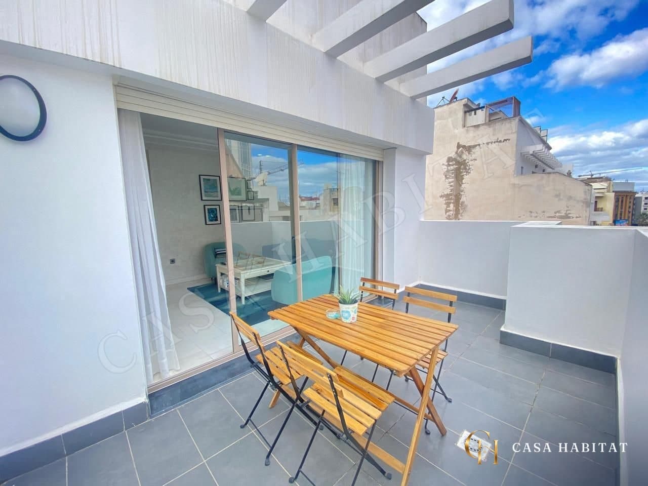 Terrasse avec table et chaises en bois, dalles grises