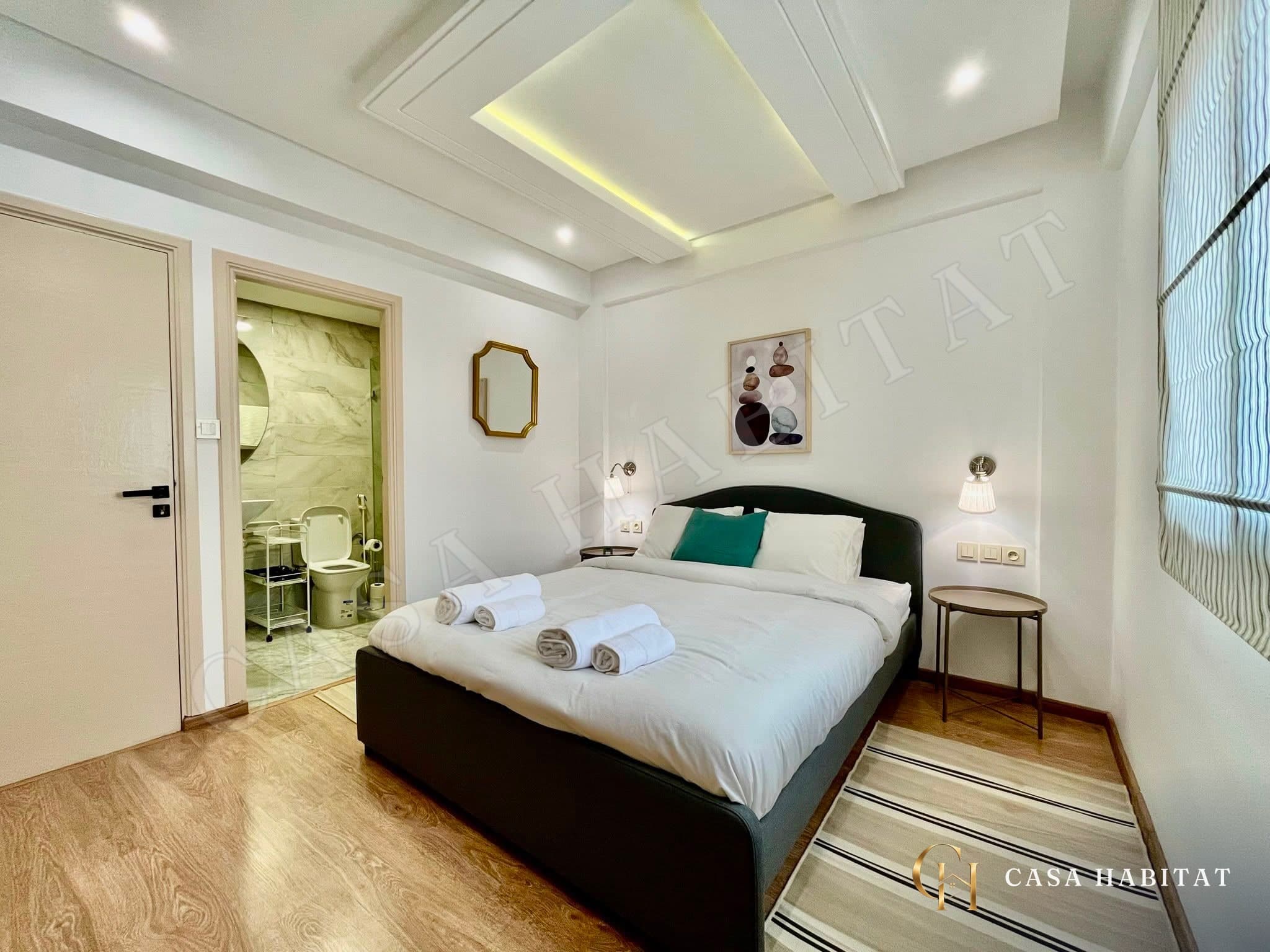 Chambre avec lit double, salle d'eau visible à gauche