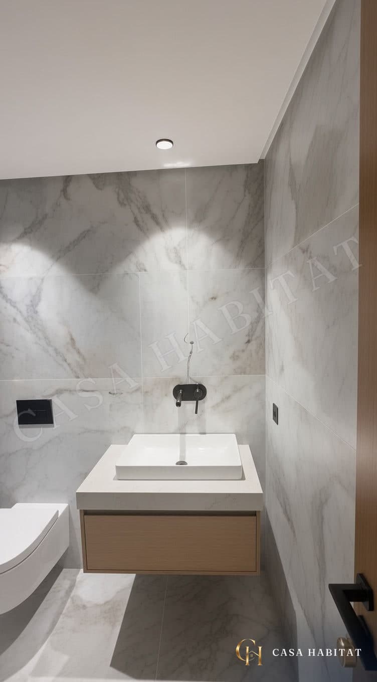 Toilettes à murs en marbre gris, vasque blanche et meuble en bois