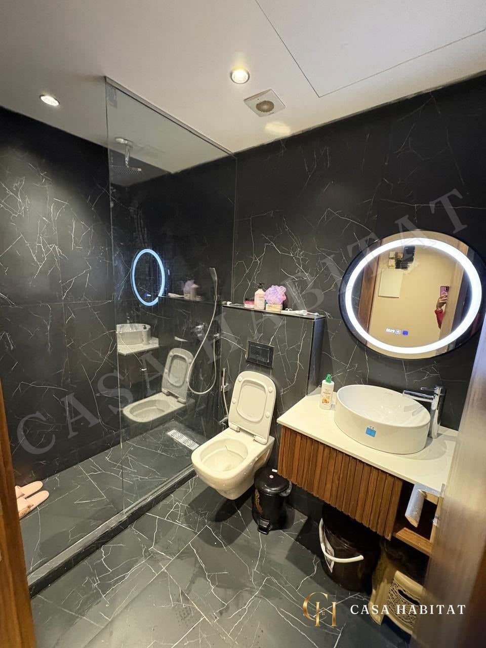 Salle de bain avec douche à l'italienne, vasque ronde et miroir lumineux