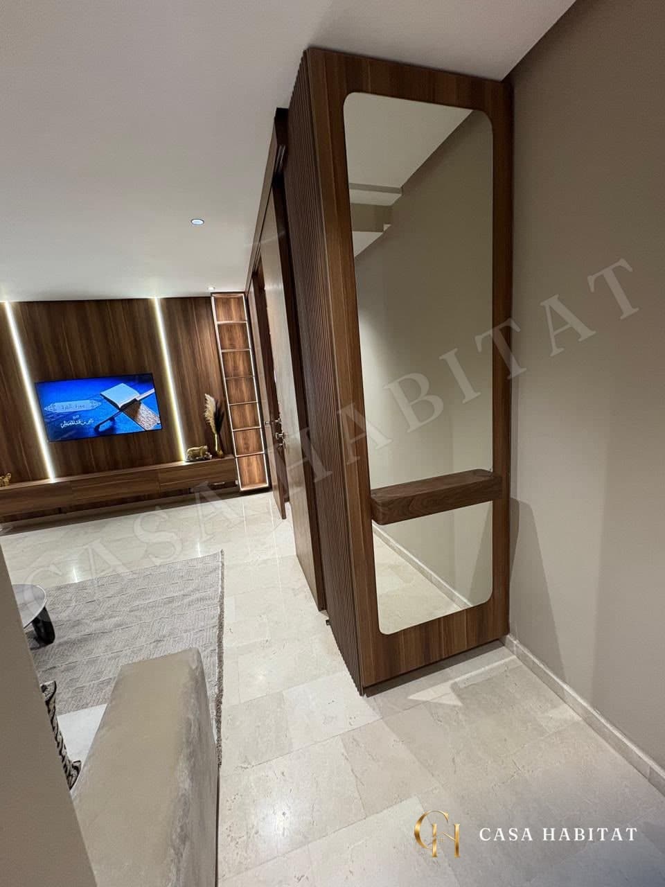Couloir avec grand miroir en bois menant au salon