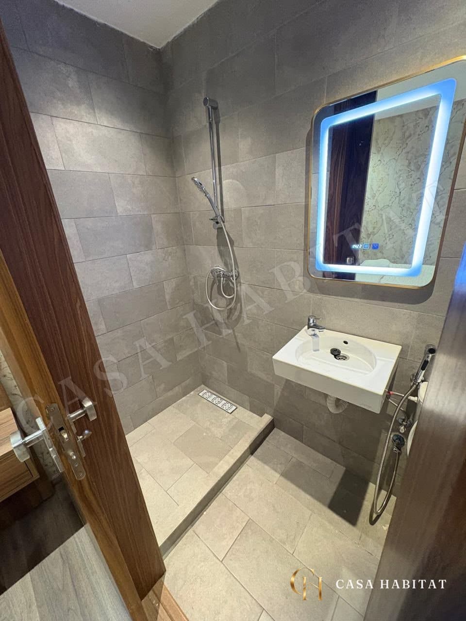 Salle de bain avec douche à l'italienne et lavabo à miroir lumineux