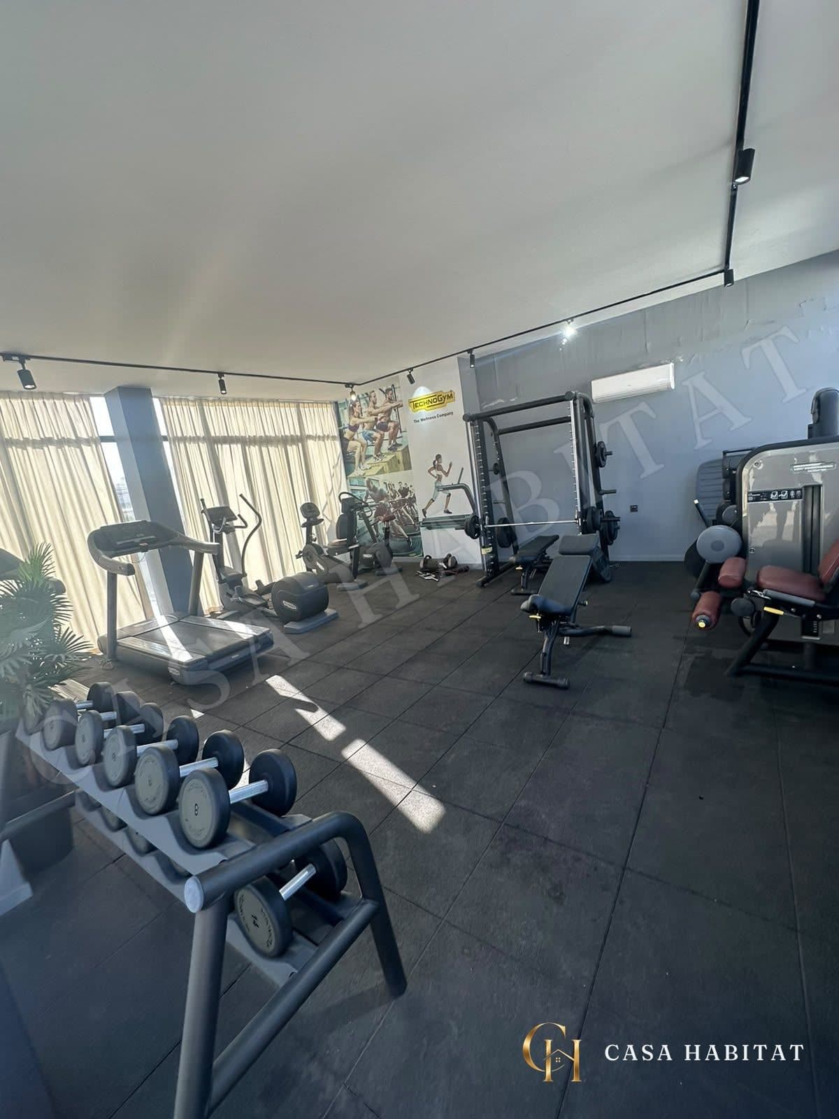 Salle de sport avec tapis de course et haltères