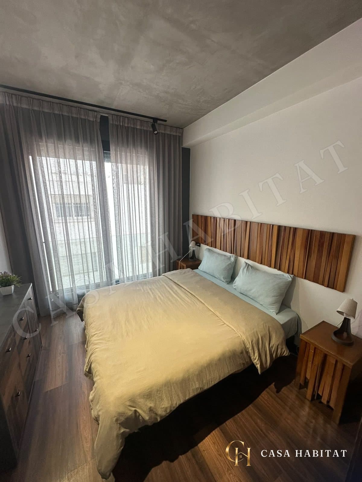 Chambre avec lit double et tête de lit en bois