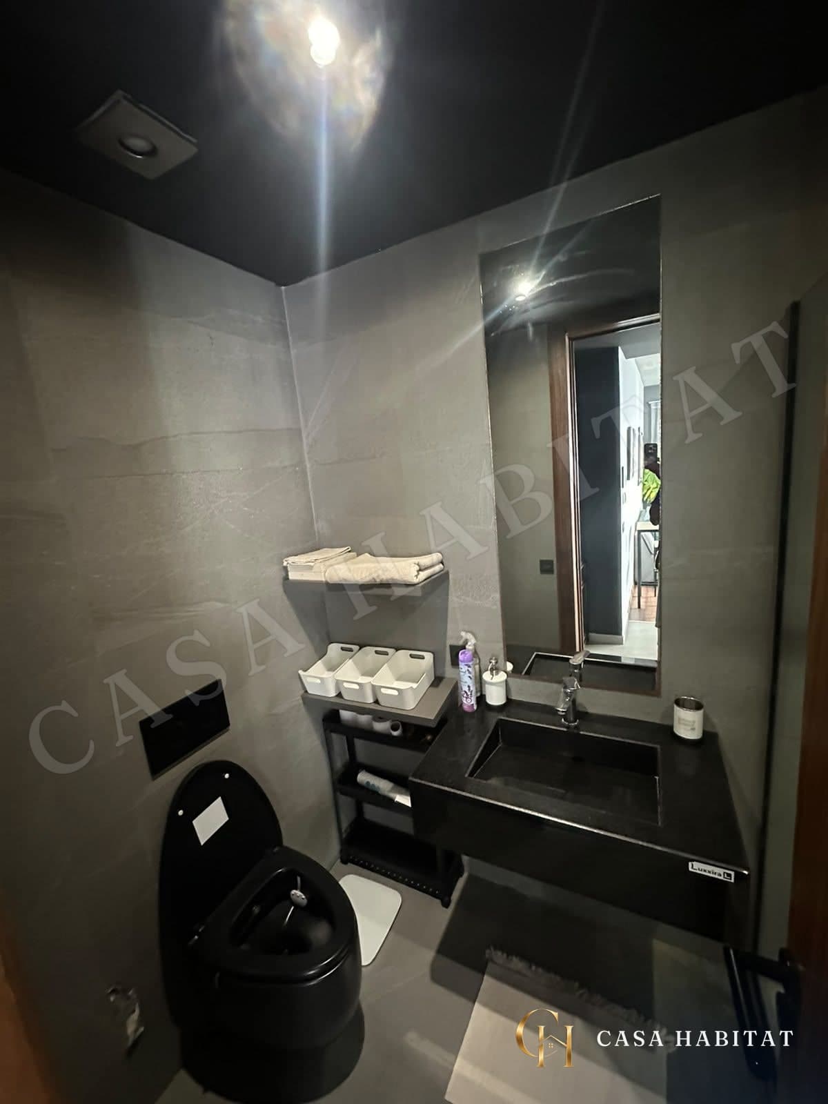 Salle de bain avec lavabo noir et toilettes
