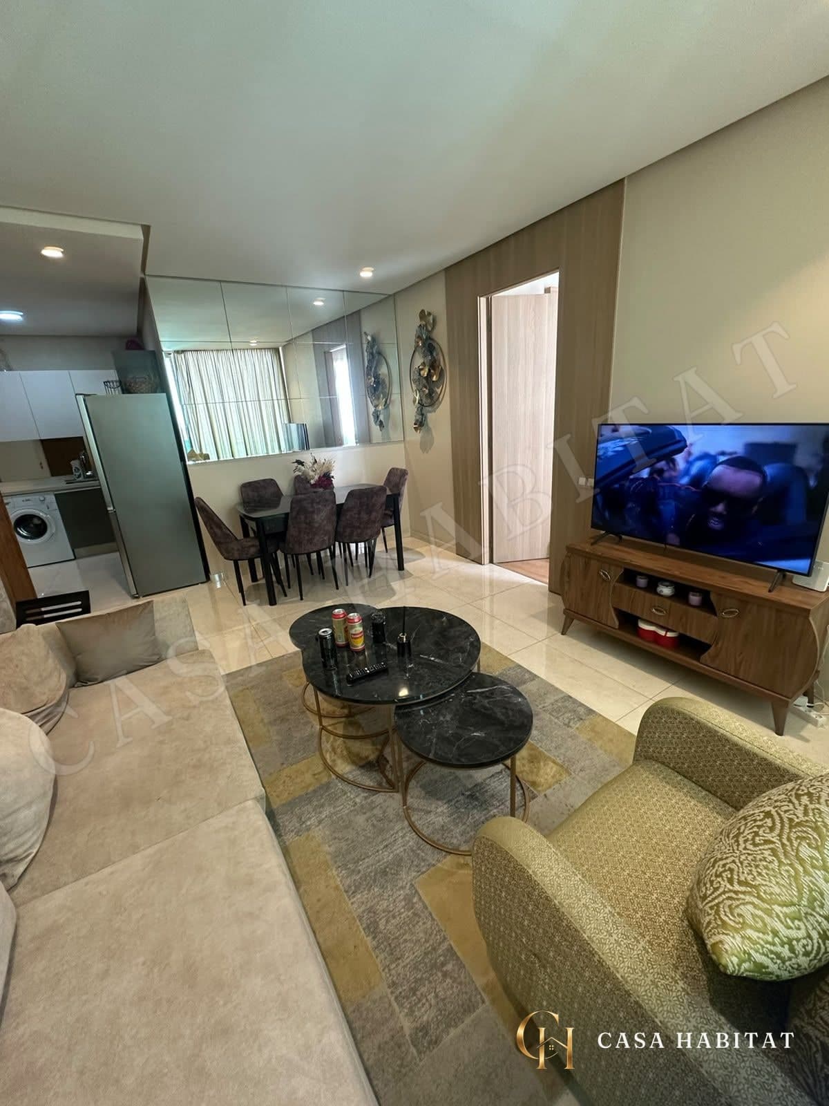 Salon avec canapé, fauteuil et télévision sur meuble en bois