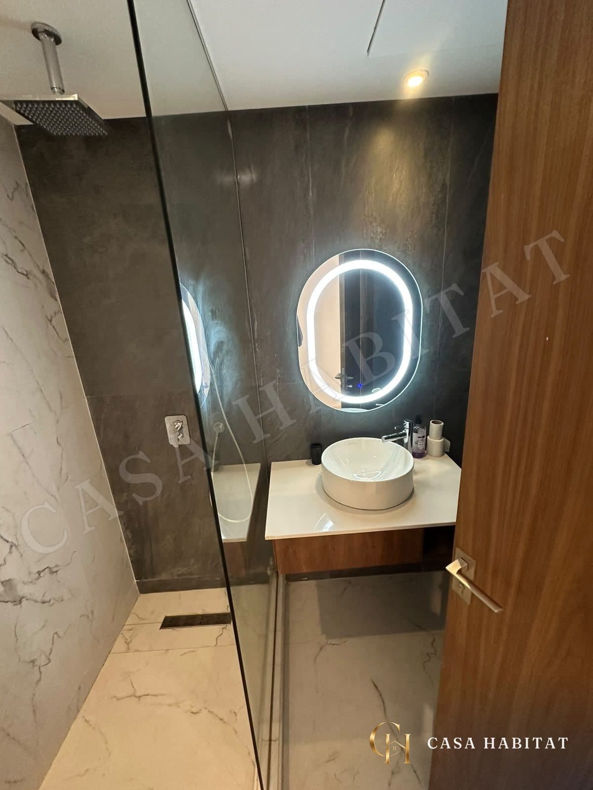 Salle de bain avec vasque blanche et miroir lumineux