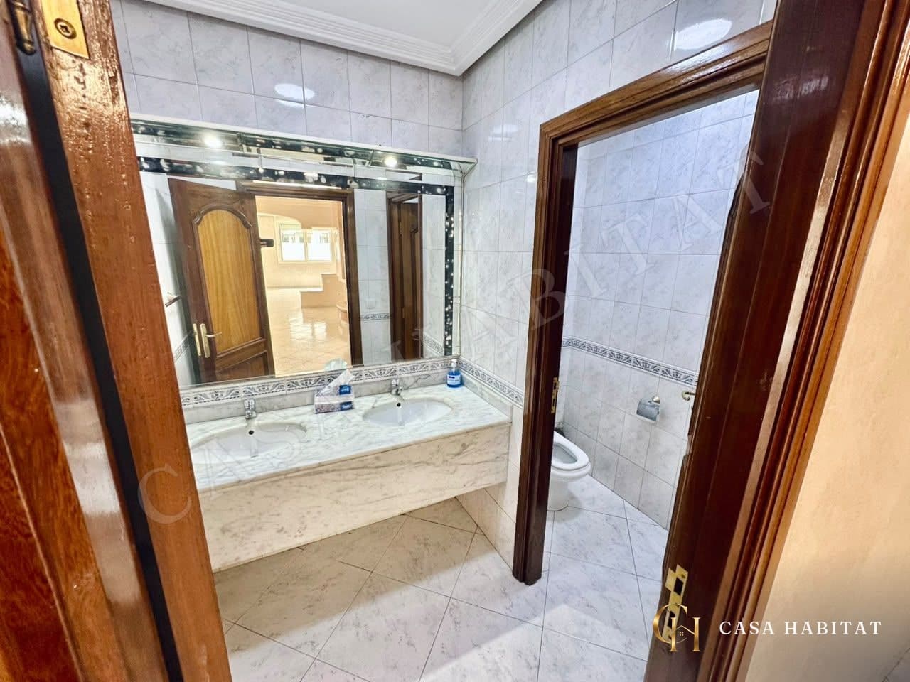 Salle de bain avec double vasque en marbre et miroir
