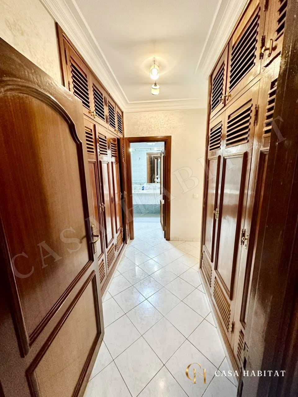 Couloir avec placards en bois et carrelage clair