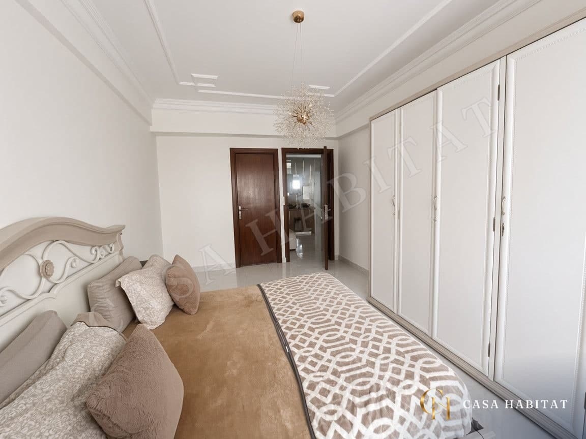 Chambre avec lit blanc, penderie blanche et suspension
