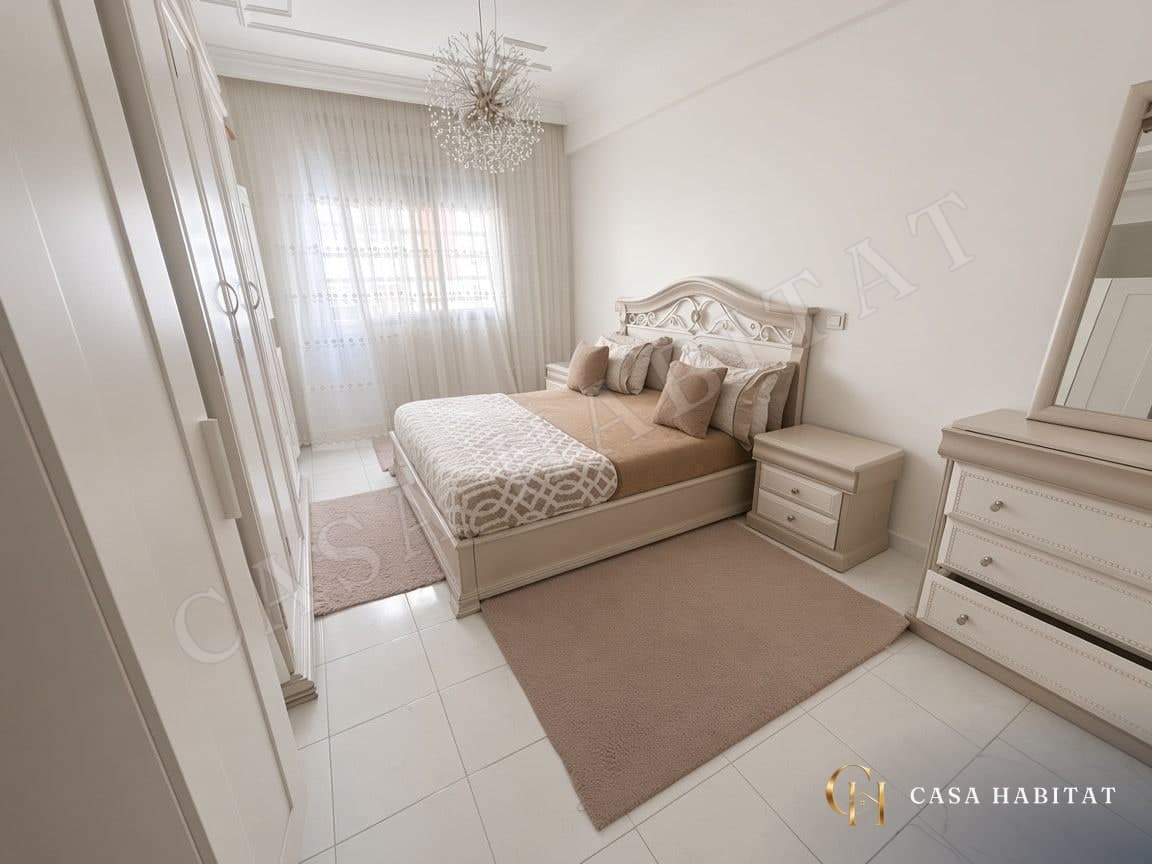 Chambre avec lit, commode et rideaux voilage