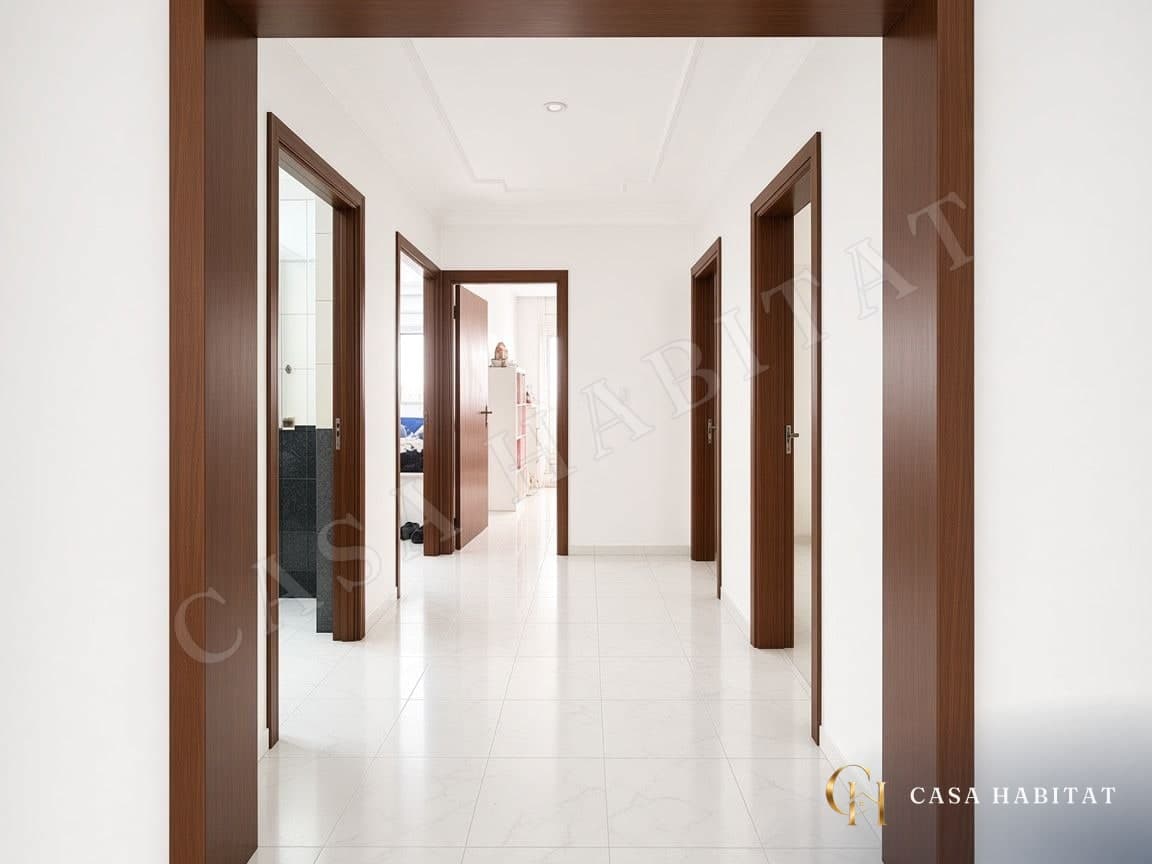 Couloir carrelé avec portes en bois menant aux pièces