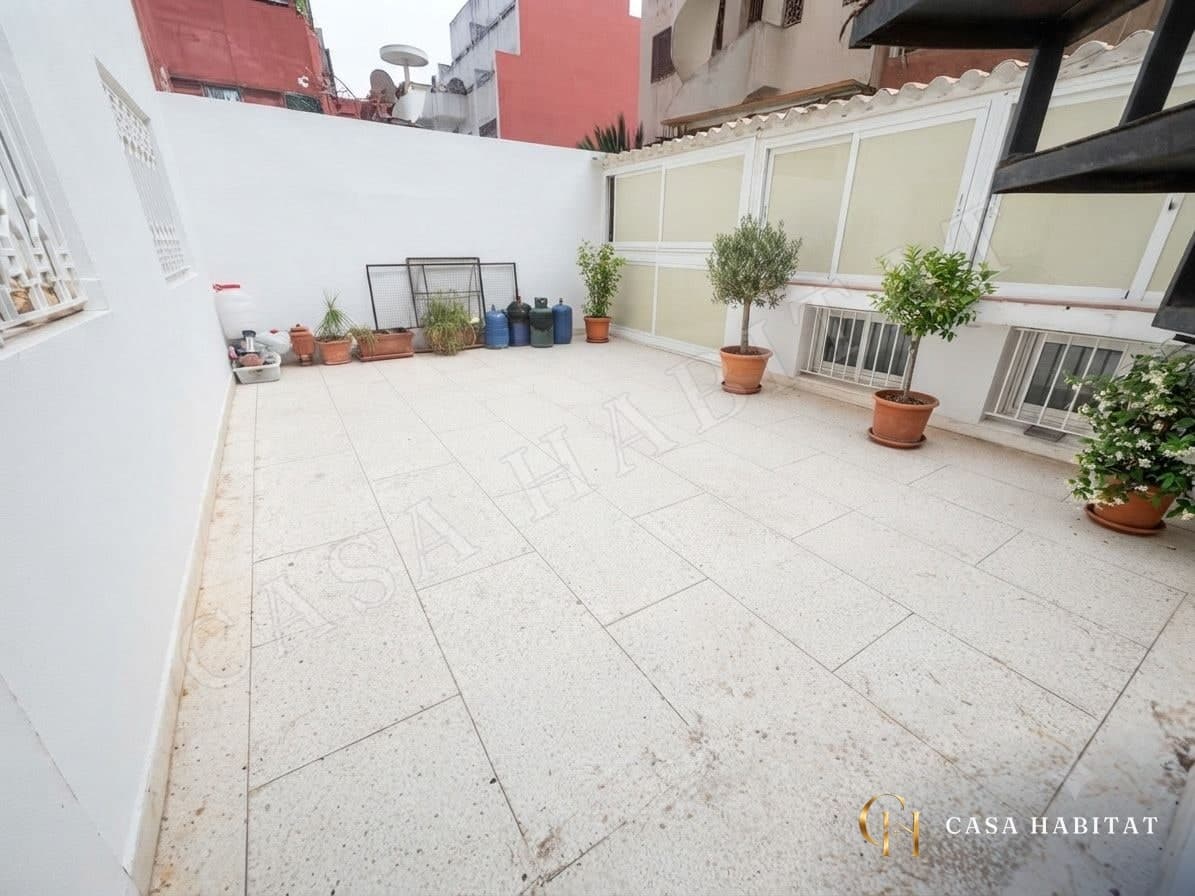 Terrasse carrelée avec plantes en pot et murs blancs