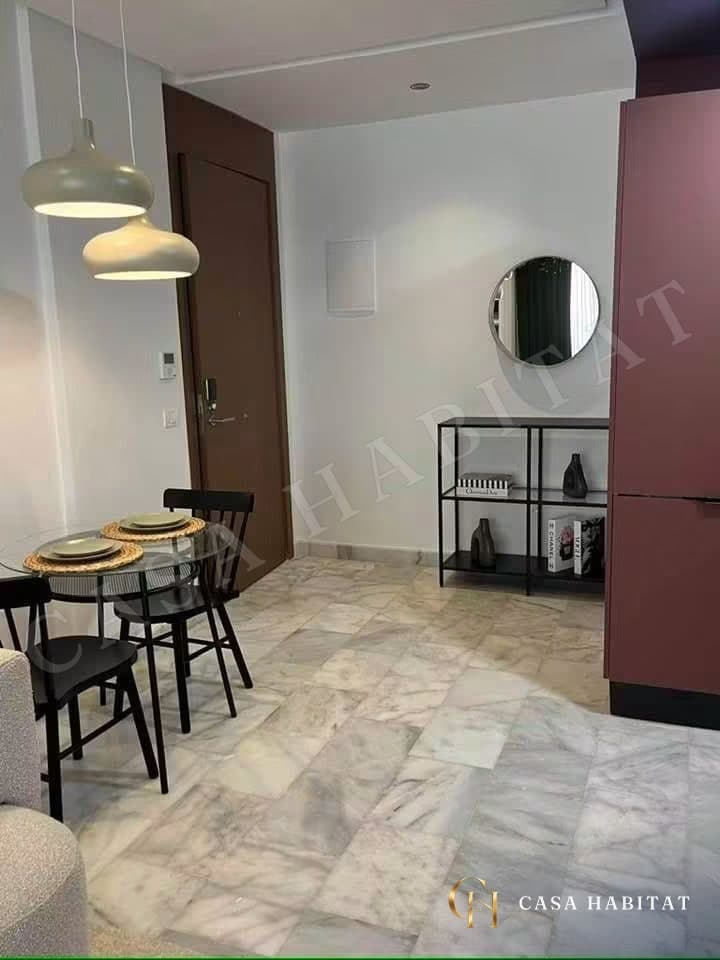 Entrée avec table à manger ronde, luminaires suspendus et meuble noir