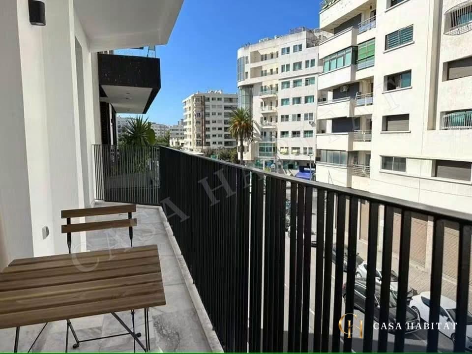 Balcon avec table et chaise en bois, vue sur immeubles