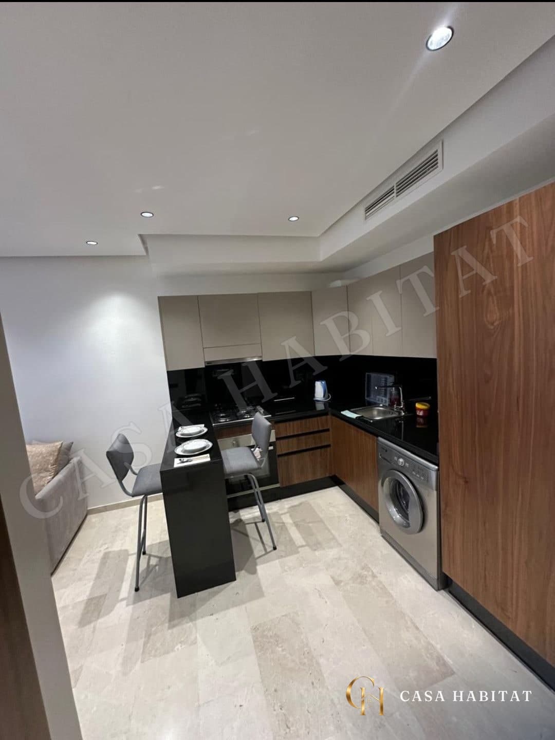 Cuisine équipée en bois et noir avec lave-linge et bar