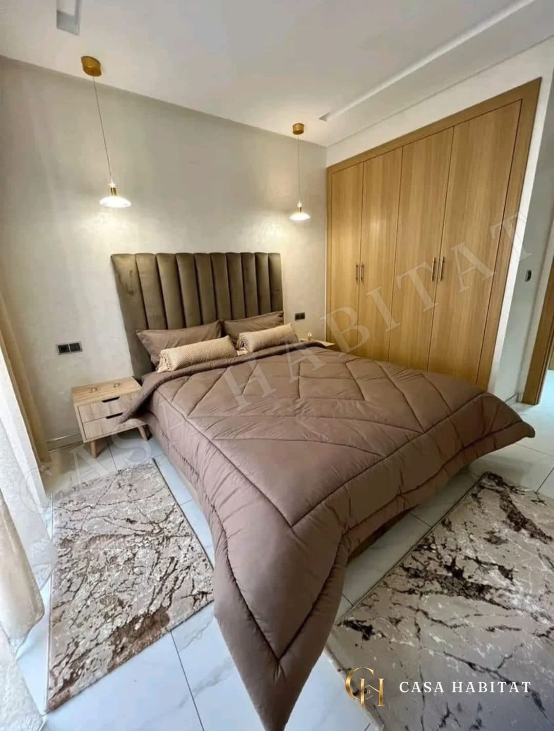 Chambre avec lit capitonné, placard en bois et tapis