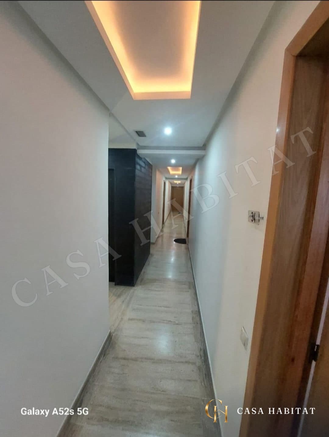 Couloir clair avec éclairage au plafond et portes en bois