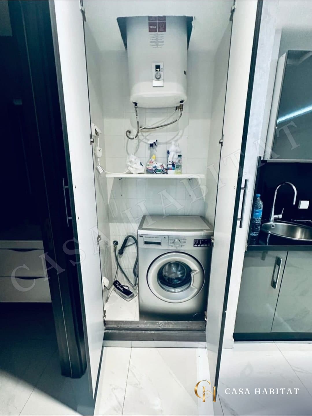 Buanderie avec lave-linge et chauffe-eau dans un placard