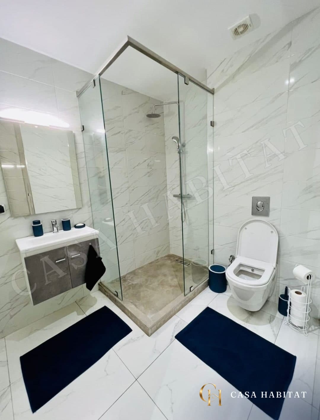 Salle de bain avec douche en verre, lavabo et toilettes