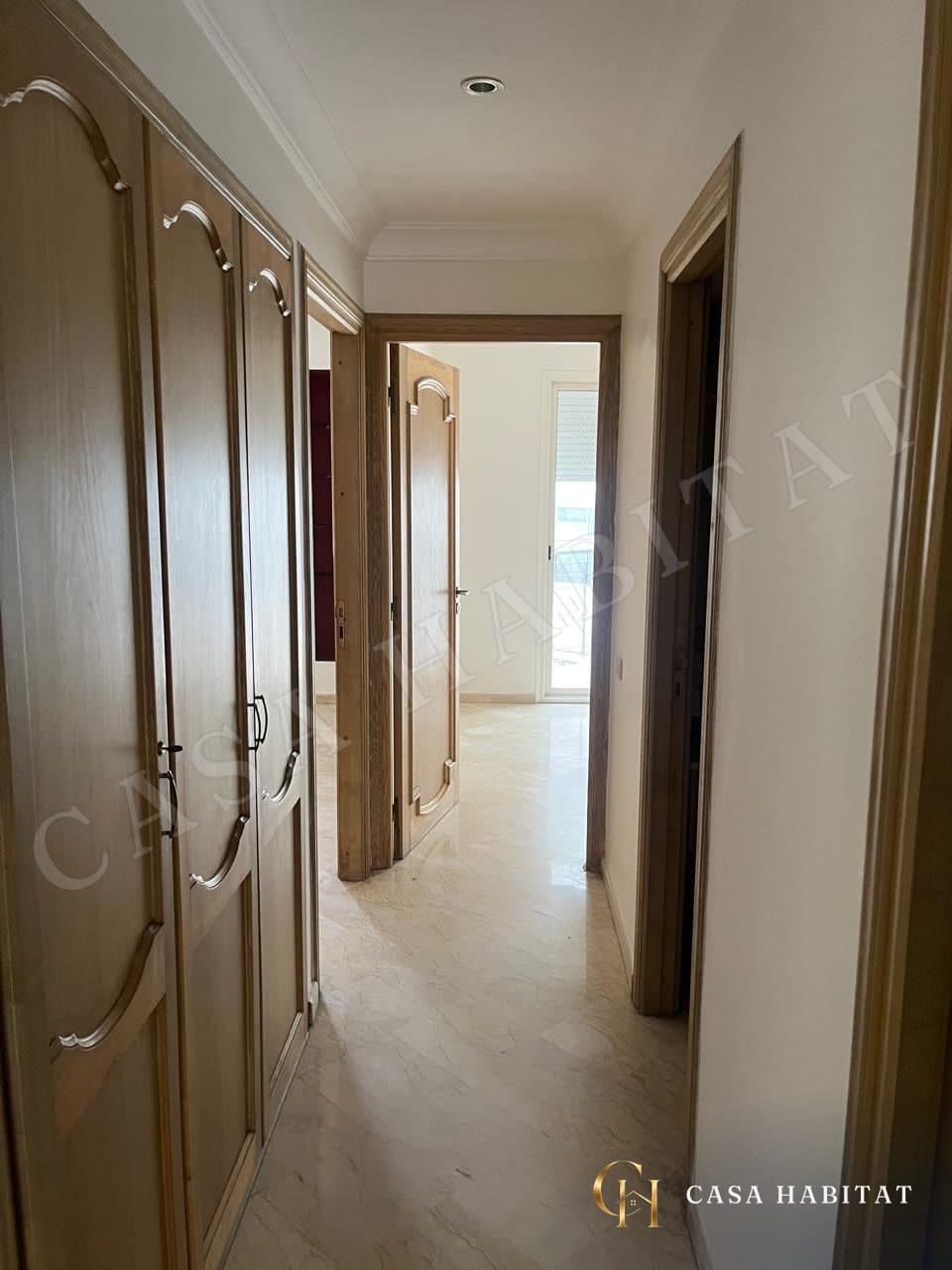Couloir avec placards en bois et porte ouverte sur fenêtre