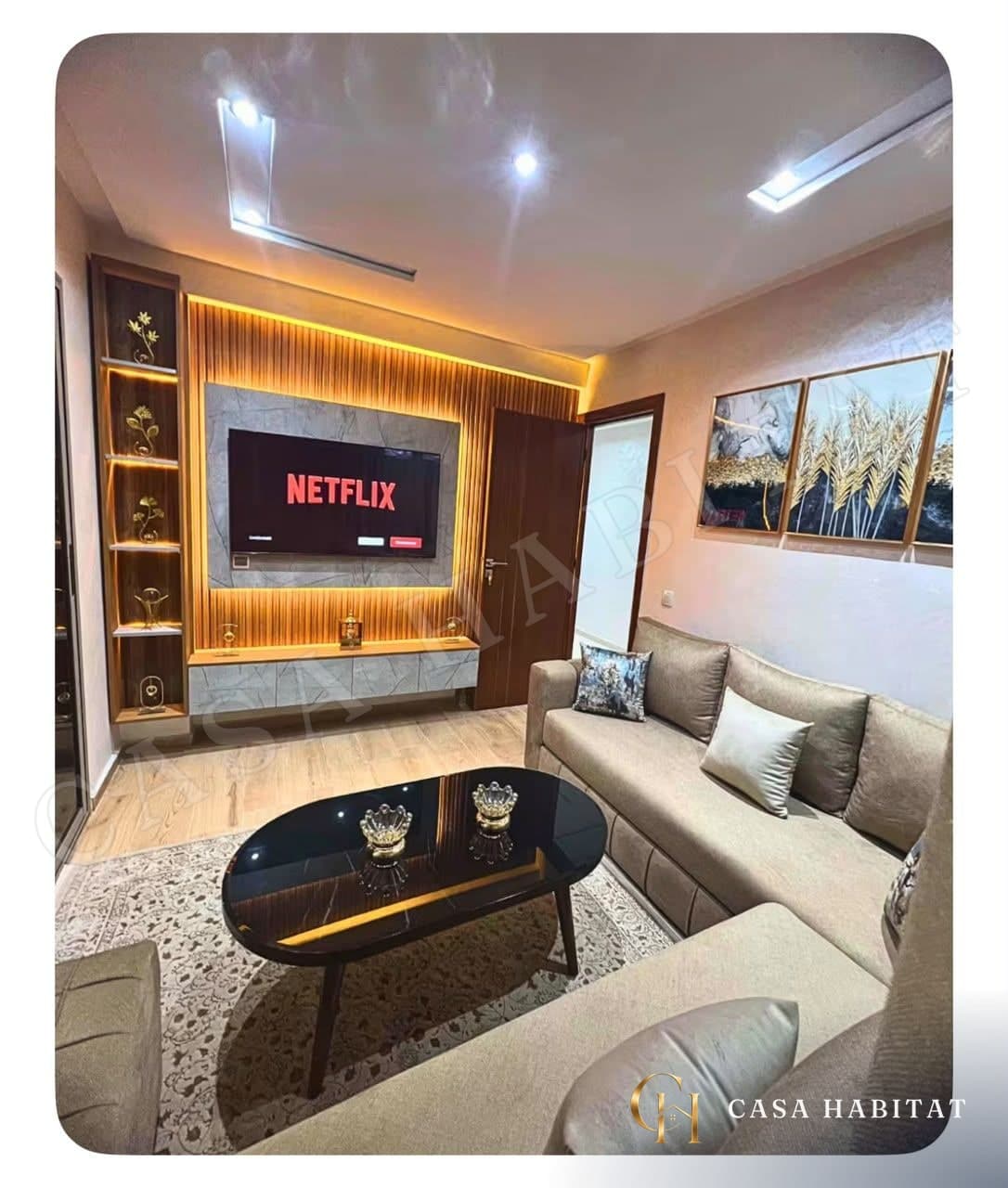 Salon avec meuble TV à éclairage LED, canapé beige et table basse noire