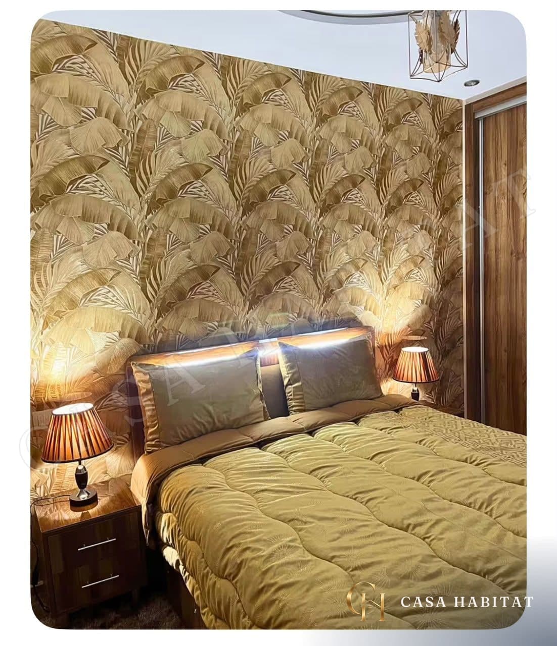 Chambre avec lit doublé, papier peint feuillage doré et lampes de chevet