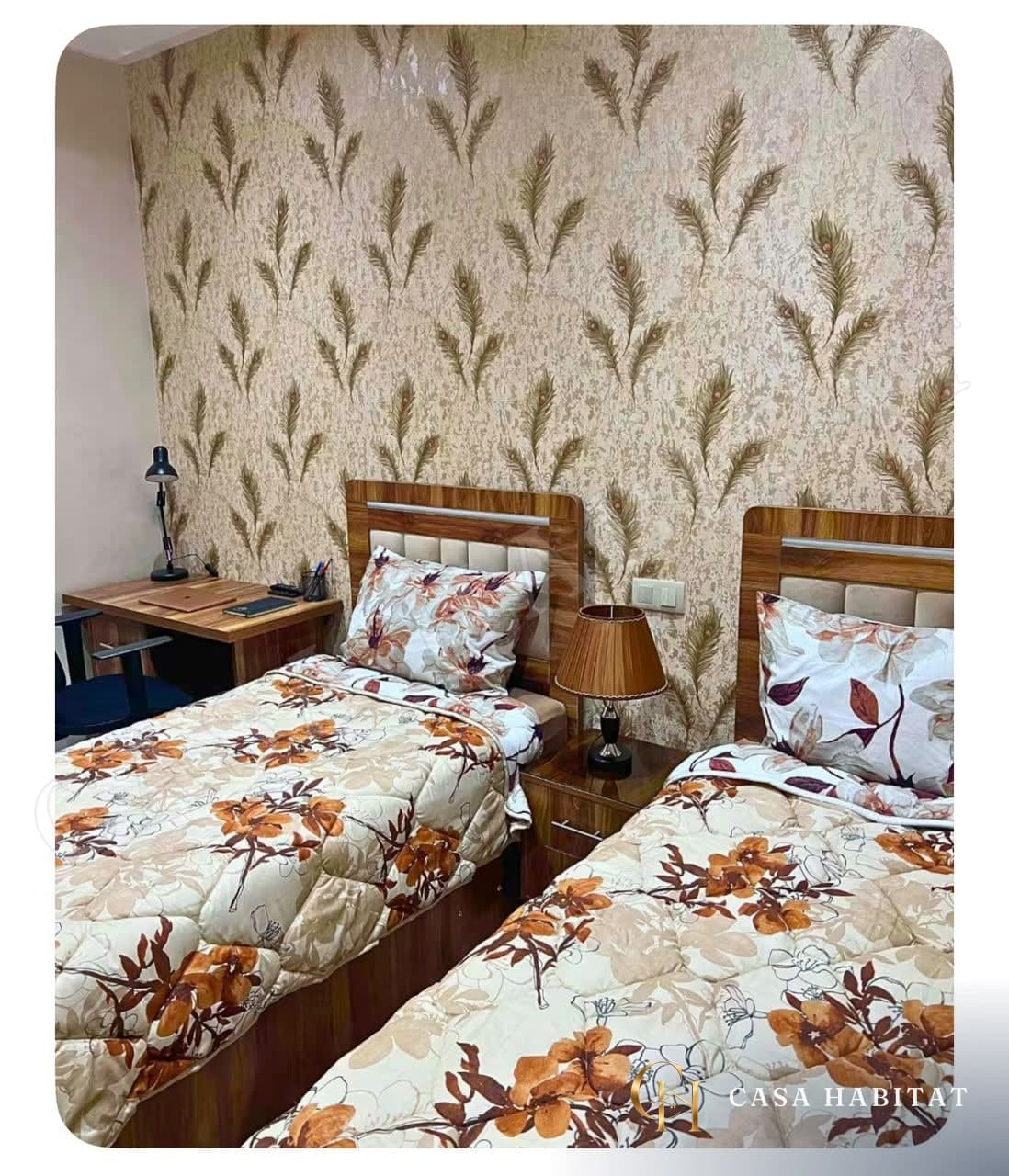 Chambre avec deux lits simples, papier peint à motifs et bureau en bois