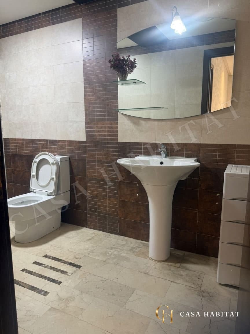 Salle de bain avec WC, lavabo sur colonne et miroir