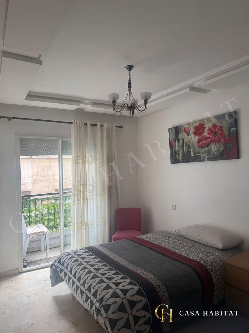 Chambre avec lit double, balcon et lustre suspendu