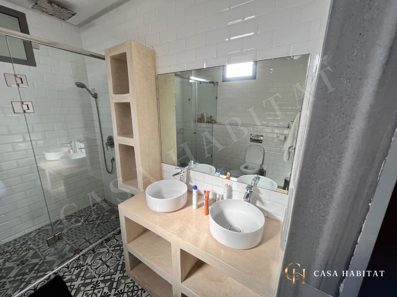 Salle de bain avec double vasque, miroir et douche vitrée