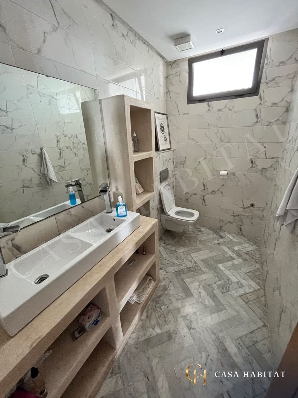 Salle de bain avec vasque, WC suspendu et carrelage marbré