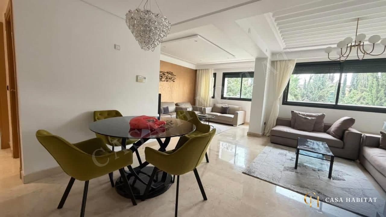 Salle à manger avec table ronde, chaises vertes et lustre en cristal