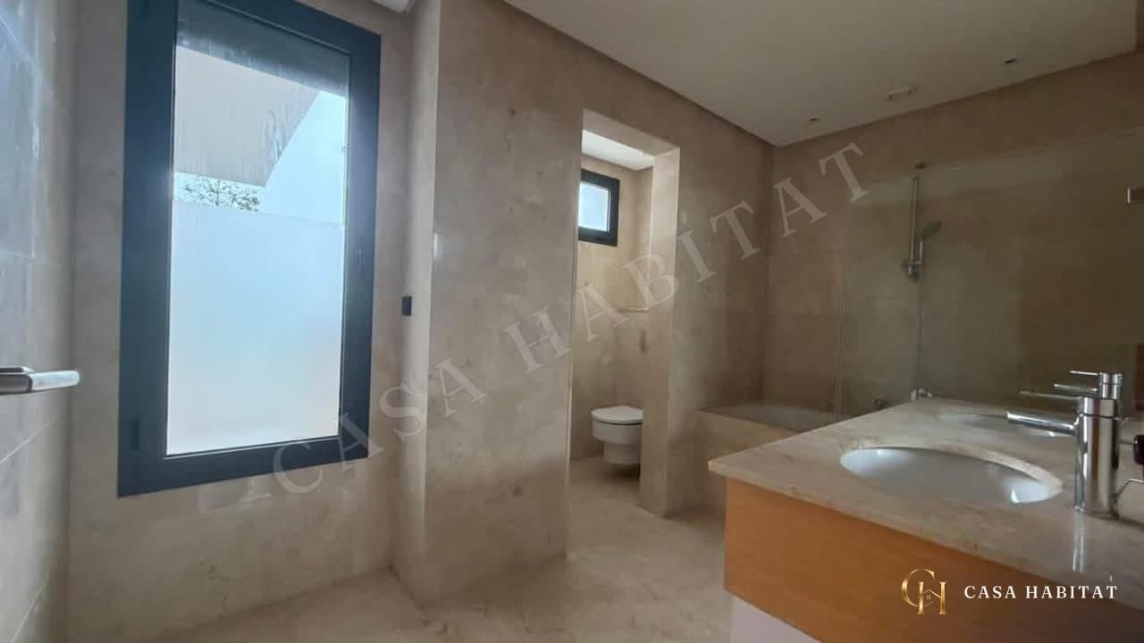 Salle de bain en marbre avec lavabo, baignoire et fenêtre