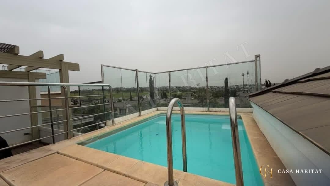 Piscine rectangulaire en terrasse avec garde-corps en verre et échelles inox