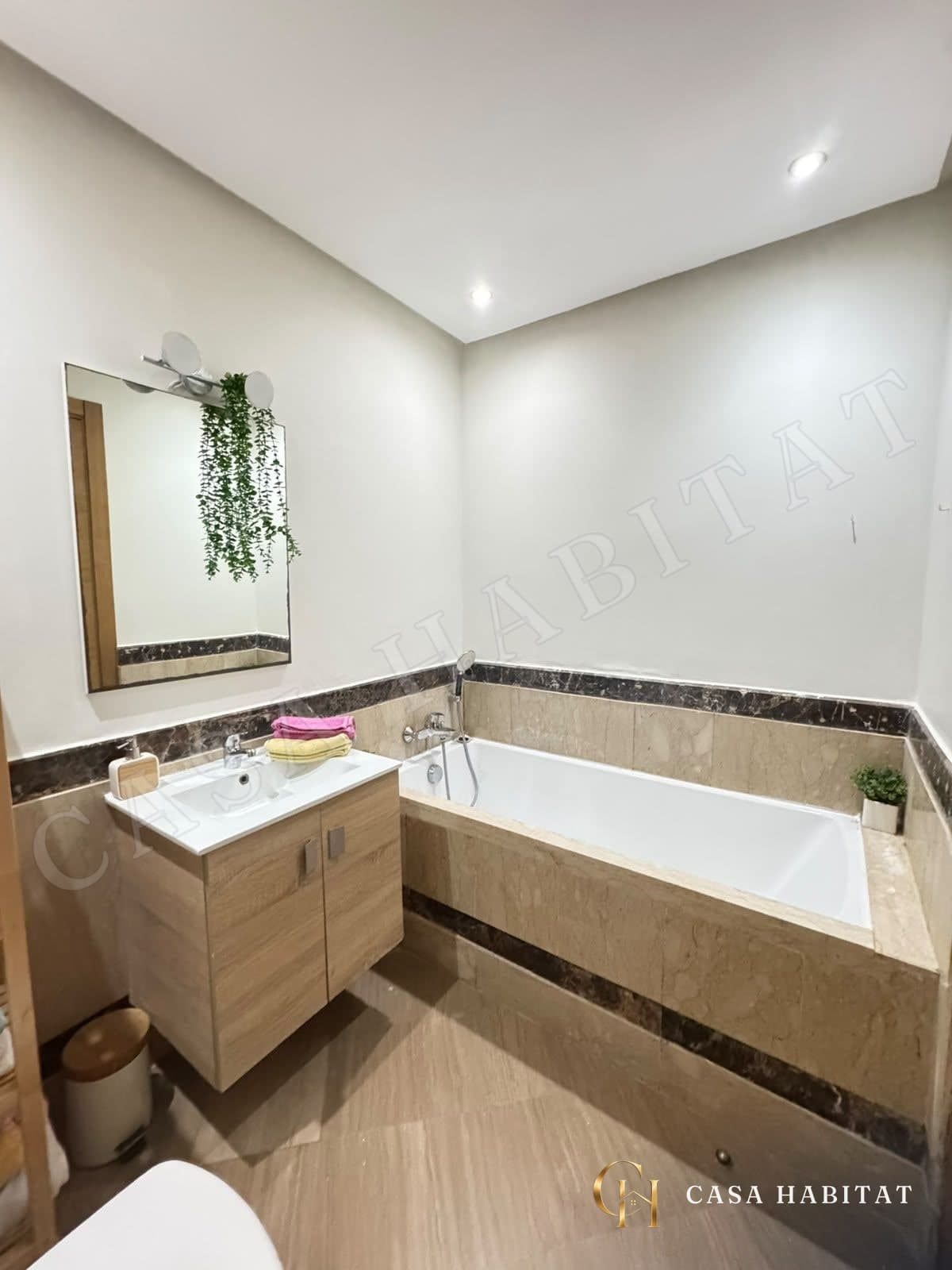 Salle de bain avec baignoire, vasque en bois et miroir